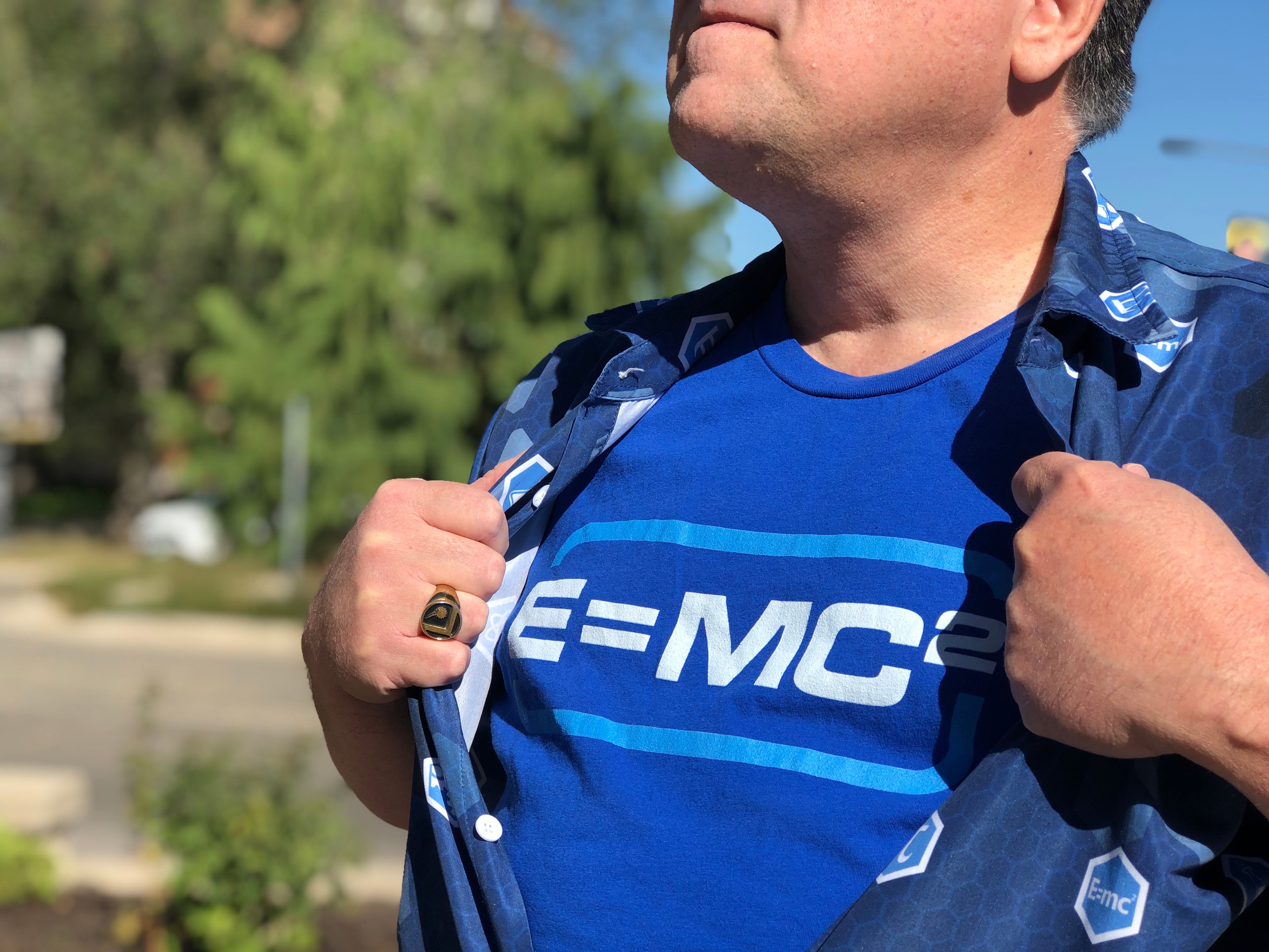 Man wearing G-WHIZ Aloha Shirt over a graphic t-shirt displaying E=MC Squared.